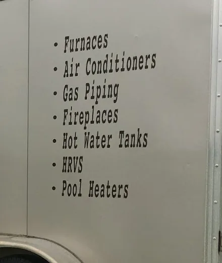 The side of a silver work trailer lettered with a list: Furnaces, Air Conditioners, Gas Piping, Fireplaces, Hot Water Tanks, HRVS and Pool Heaters.